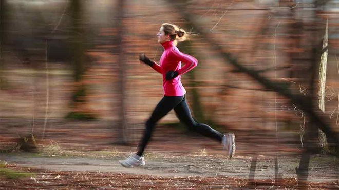 woman jogging fast in forest